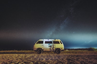 White and brown van parked in the perspective of the Milky Way
